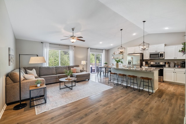4315 E 48th St, Des Moines, IA 50317 - living room featuring vaulted ceiling, a ceiling fan, wood finished floors, and recessed lighting