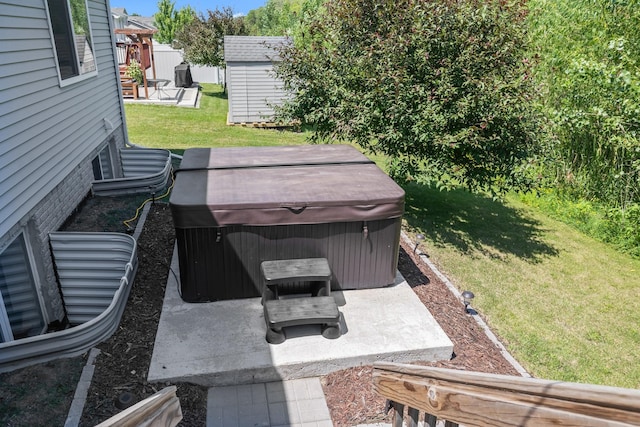 4315 E 48th St, Des Moines, IA 50317 - view of green lawn featuring a hot tub, a patio area, and a storage unit