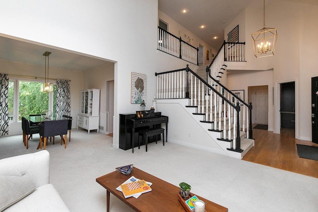 14092 Lake Pointe Dr, Clive, IA 50325 - carpeted living room featuring a chandelier, a high ceiling, stairway, and recessed lighting