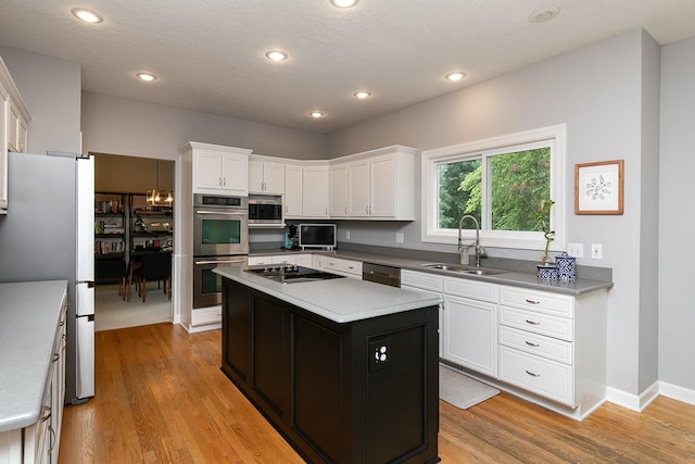 14092 Lake Pointe Dr, Clive, IA 50325 - kitchen featuring stainless steel appliances, white cabinetry, light wood-style floors, recessed lighting, and a textured ceiling