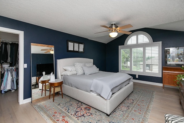 14092 Lake Pointe Dr, Clive, IA 50325 - bedroom featuring lofted ceiling, light wood-type flooring, a textured ceiling, and a ceiling fan