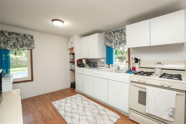 808 Bridge St, Redfield, IA 50233 - kitchen with white gas stove, light countertops, plenty of natural light, and white cabinets