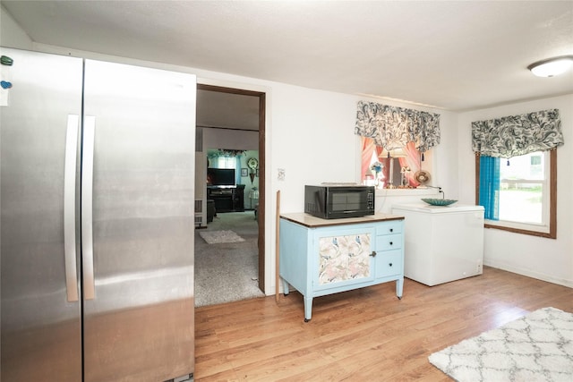 808 Bridge St, Redfield, IA 50233 - bedroom with freestanding refrigerator, light wood-type flooring, and fridge