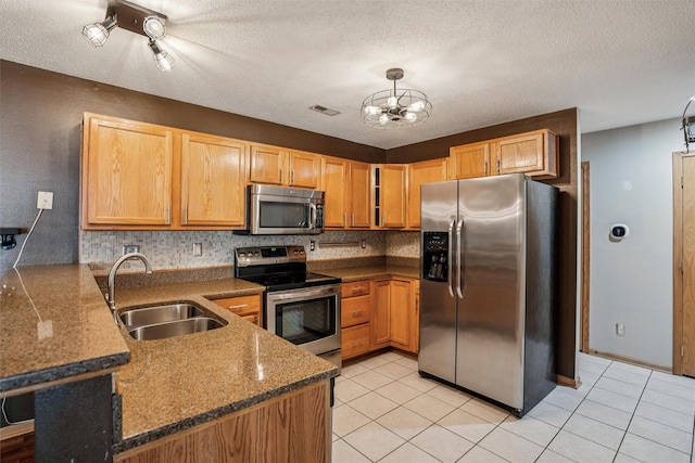 1517 SE Delaware Ave Unit 2, Ankeny, IA 50021 - kitchen featuring appliances with stainless steel finishes, a peninsula, a chandelier, light tile patterned flooring, and a textured ceiling