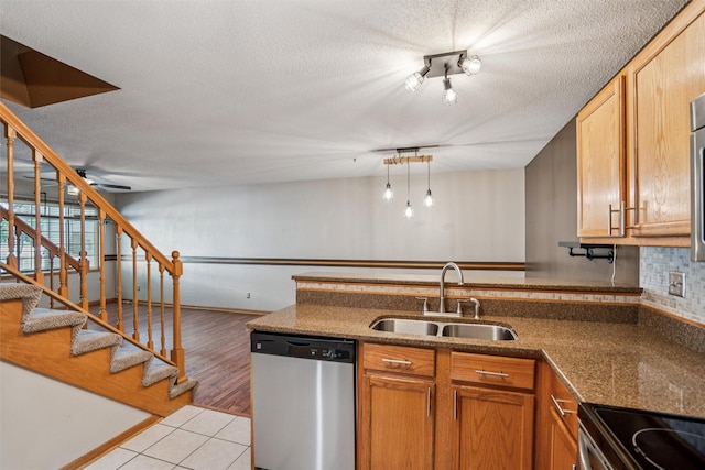 1517 SE Delaware Ave Unit 2, Ankeny, IA 50021 - kitchen featuring dishwasher, a peninsula, light tile patterned floors, a textured ceiling, and decorative backsplash