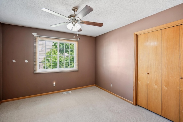 1517 SE Delaware Ave Unit 2, Ankeny, IA 50021 - unfurnished bedroom featuring light colored carpet, a closet, a textured ceiling, and a ceiling fan
