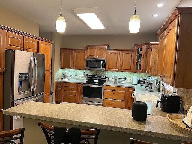 2279 Pheasant Ridge Ln, Ames, IA 50010 - kitchen with stainless steel appliances, a peninsula, brown cabinets, and backsplash