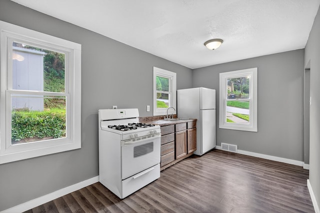 34 E Broadway St, Colfax, IA 50054 - kitchen with white appliances, dark wood-style flooring, and a textured ceiling