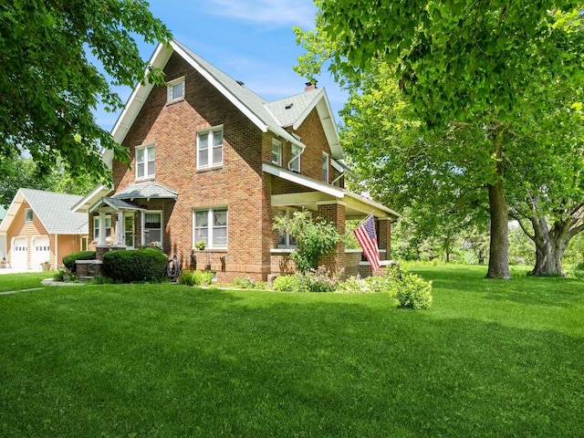 4987 E 28th St N, Newton, IA 50208 - view of front of home with brick siding, a front yard, and a chimney
