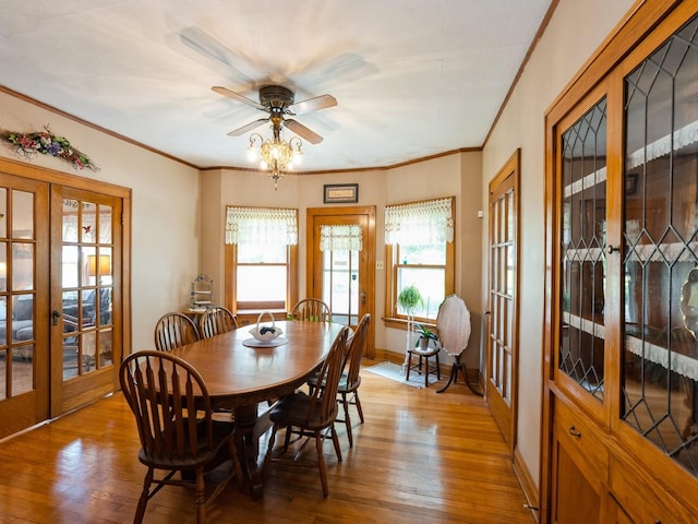 4987 E 28th St N, Newton, IA 50208 - dining area featuring french doors, light wood-style floors, ceiling fan, and crown molding