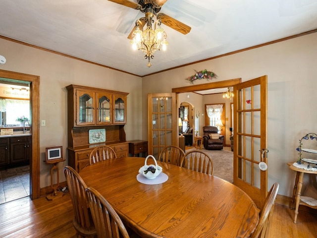 4987 E 28th St N, Newton, IA 50208 - dining space featuring french doors, a ceiling fan, light wood finished floors, and crown molding