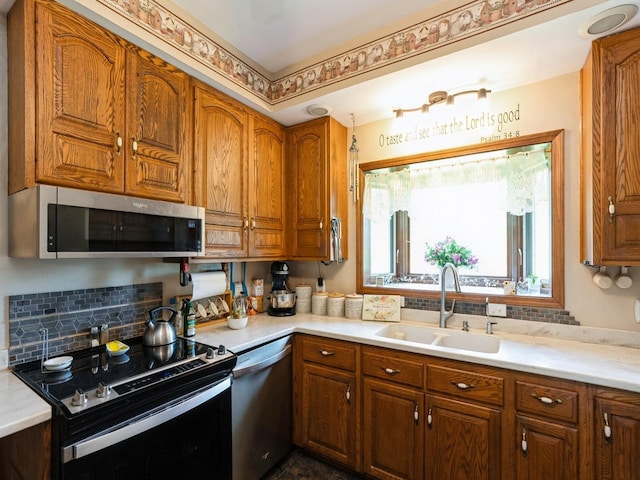 4987 E 28th St N, Newton, IA 50208 - kitchen with stainless steel appliances, brown cabinetry, light countertops, and decorative backsplash