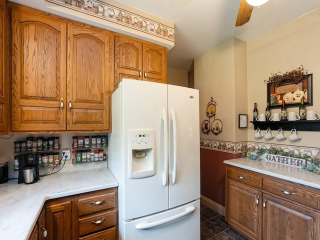 4987 E 28th St N, Newton, IA 50208 - kitchen featuring white refrigerator with ice dispenser, brown cabinetry, light countertops, a wainscoted wall, and a ceiling fan