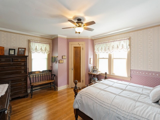 4987 E 28th St N, Newton, IA 50208 - bedroom with wallpapered walls, light wood-style flooring, crown molding, and ceiling fan