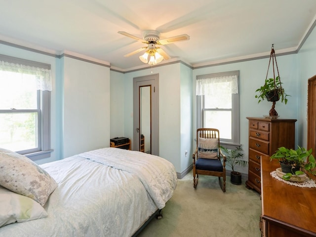 4987 E 28th St N, Newton, IA 50208 - bedroom featuring light colored carpet, multiple windows, crown molding, and ceiling fan