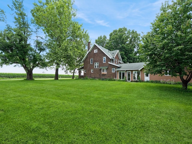4987 E 28th St N, Newton, IA 50208 - view of front of house featuring a front yard, a chimney, and a metal roof