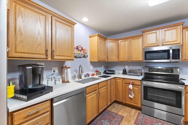 827 SW 46th St, Ankeny, IA 50023 - kitchen featuring appliances with stainless steel finishes, light wood-type flooring, light countertops, a textured ceiling, and recessed lighting