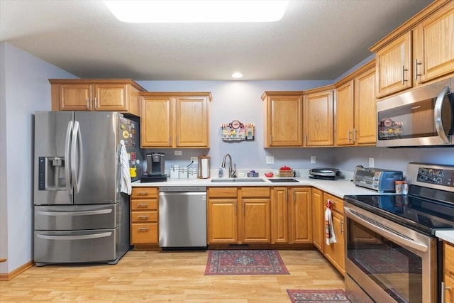 827 SW 46th St, Ankeny, IA 50023 - kitchen featuring stainless steel appliances, light wood-style flooring, light countertops, recessed lighting, and a textured ceiling