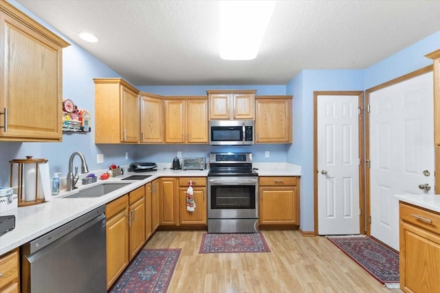 827 SW 46th St, Ankeny, IA 50023 - kitchen with appliances with stainless steel finishes, light wood finished floors, light countertops, a textured ceiling, and recessed lighting