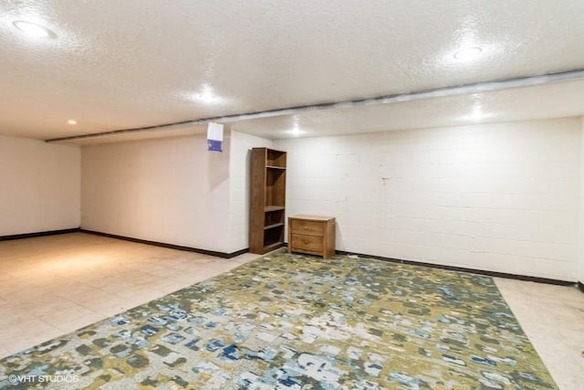 644 N 43rd St, Cumming, IA 50061 - finished basement with a textured ceiling, concrete block wall, and recessed lighting