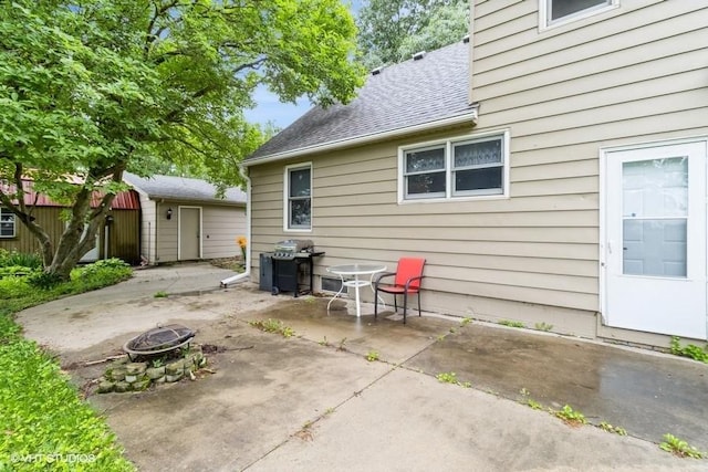 644 N 43rd St, Cumming, IA 50061 - view of patio with a fire pit, a grill, and an outbuilding