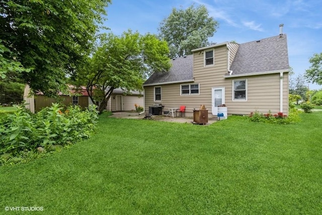 644 N 43rd St, Cumming, IA 50061 - back of property featuring a patio area, a shingled roof, and a lawn