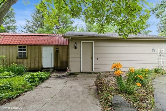 644 N 43rd St, Cumming, IA 50061 - view of front of home featuring an outbuilding, a metal roof, and a patio area