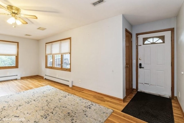 644 N 43rd St, Cumming, IA 50061 - entrance foyer featuring a baseboard heating unit, light wood-style floors, and ceiling fan