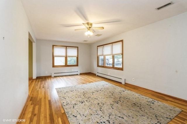 644 N 43rd St, Cumming, IA 50061 - spare room with a baseboard heating unit, ceiling fan, and light wood-style floors