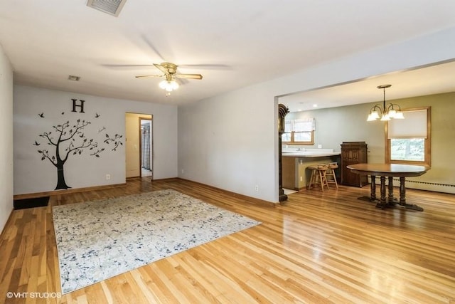 644 N 43rd St, Cumming, IA 50061 - unfurnished room featuring wood finished floors, a ceiling fan, and a chandelier
