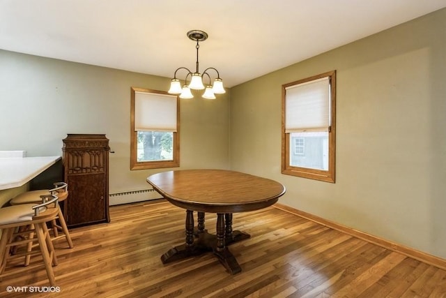 644 N 43rd St, Cumming, IA 50061 - dining area with plenty of natural light, light wood finished floors, and a baseboard heating unit