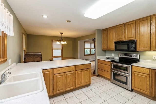644 N 43rd St, Cumming, IA 50061 - kitchen featuring black microwave, range with two ovens, brown cabinetry, a chandelier, and recessed lighting