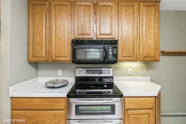 644 N 43rd St, Cumming, IA 50061 - kitchen with black microwave, stainless steel electric range oven, light countertops, and a baseboard heating unit