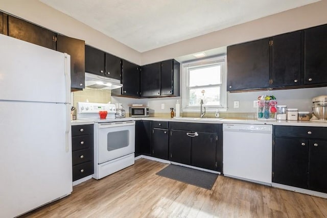 1525 Rapids St, Adel, IA 50003 - kitchen featuring white appliances, under cabinet range hood, light wood-style floors, light countertops, and dark cabinets