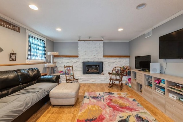 1525 Rapids St, Adel, IA 50003 - living room with ornamental molding, wood finished floors, a fireplace, recessed lighting, and track lighting