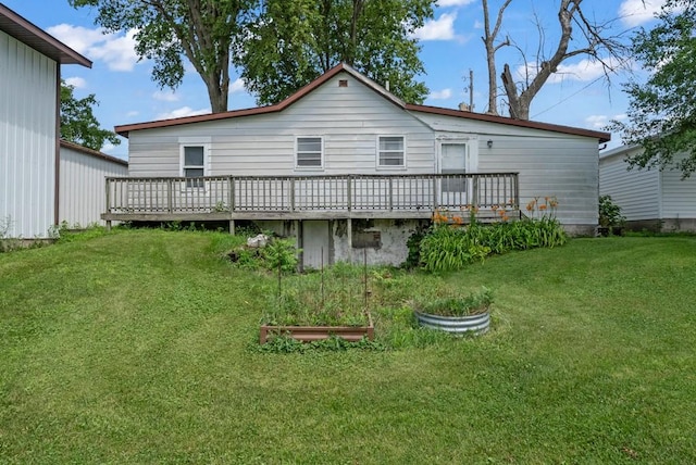 1107 E 12th St N, Newton, IA 50208 - back of property featuring a wooden deck, a garden, and a lawn