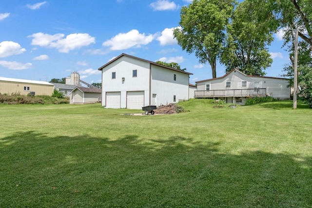 1107 E 12th St N, Newton, IA 50208 - view of grassy yard featuring a detached garage and a wooden deck