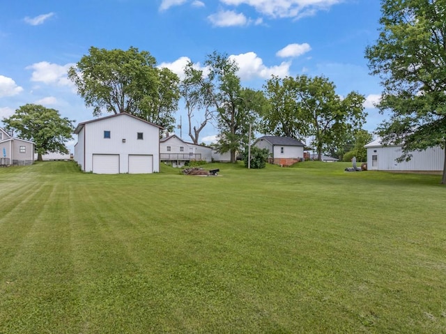 1107 E 12th St N, Newton, IA 50208 - view of grassy yard with a detached garage, an outdoor structure, and driveway