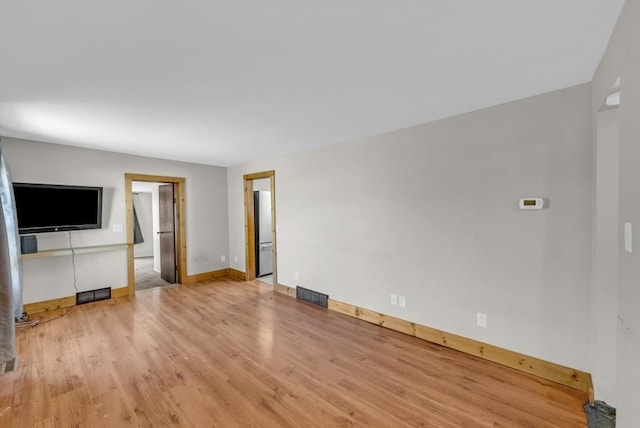 1107 E 12th St N, Newton, IA 50208 - unfurnished living room featuring light wood-type flooring and baseboards