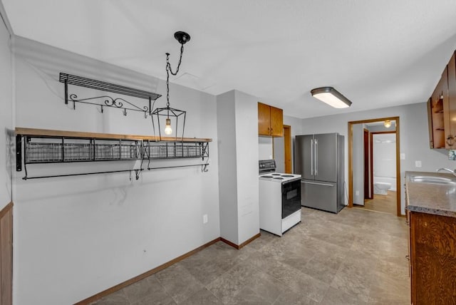 1107 E 12th St N, Newton, IA 50208 - kitchen with white range with electric cooktop, freestanding refrigerator, and brown cabinetry
