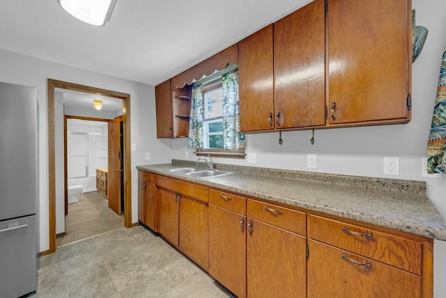 1107 E 12th St N, Newton, IA 50208 - kitchen with freestanding refrigerator, brown cabinetry, and open shelves