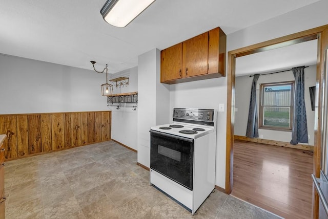 1107 E 12th St N, Newton, IA 50208 - kitchen featuring electric range, brown cabinets, and wooden walls
