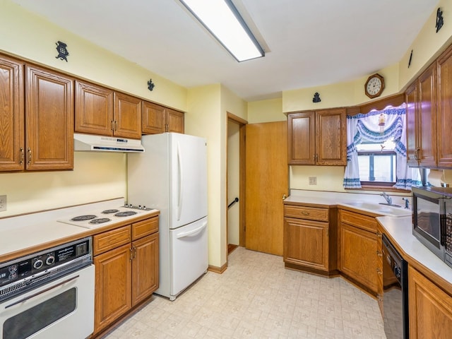 4041 Columbia St, Des Moines, IA 50313 - kitchen featuring white appliances, under cabinet range hood, brown cabinetry, and light countertops