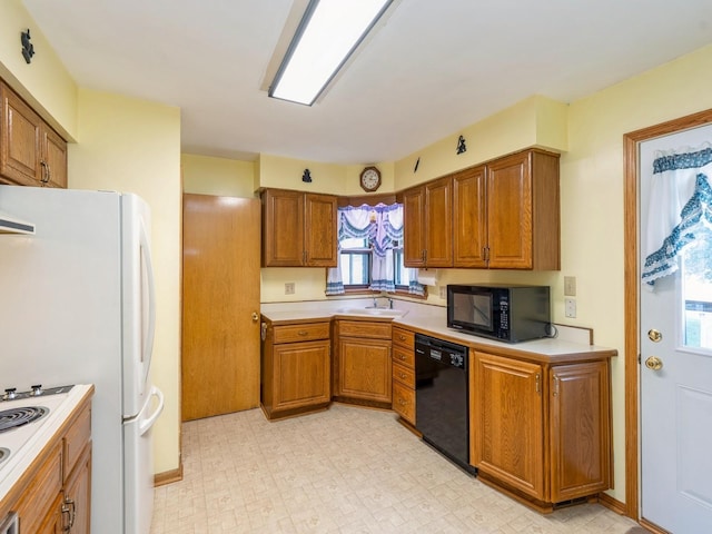 4041 Columbia St, Des Moines, IA 50313 - kitchen featuring black appliances, brown cabinets, light countertops, and light flooring