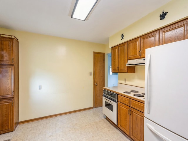 4041 Columbia St, Des Moines, IA 50313 - kitchen with white appliances, under cabinet range hood, brown cabinets, and light floors
