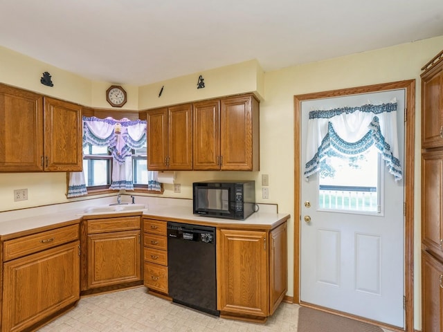 4041 Columbia St, Des Moines, IA 50313 - kitchen featuring black appliances, brown cabinetry, and light countertops