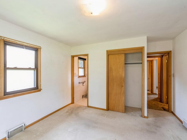 4041 Columbia St, Des Moines, IA 50313 - unfurnished bedroom featuring light carpet, a baseboard radiator, a closet, and connected bathroom