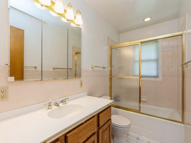 4041 Columbia St, Des Moines, IA 50313 - bathroom with vanity, combined bath / shower with glass door, tile walls, tile patterned floors, and recessed lighting