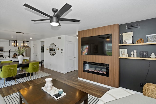 1413 NE Park St, Grimes, IA 50111 - living room with a ceiling fan, dark wood finished floors, and a glass covered fireplace
