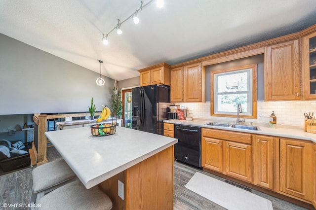 500 NW Valley View Dr, Grimes, IA 50111 - kitchen featuring black appliances, lofted ceiling, a kitchen bar, wood finished floors, and tasteful backsplash